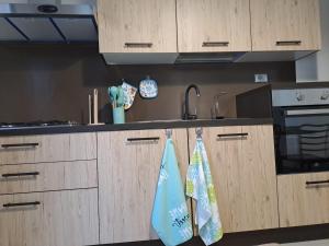 una cocina con armarios de madera y toallas colgadas de ellos en Casa Maia, en Poggiardo