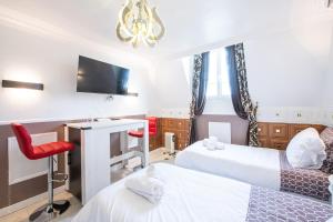 a hotel room with two beds and a desk at Studio Marron - Paris à 10 min - RER in Deuil-la-Barre