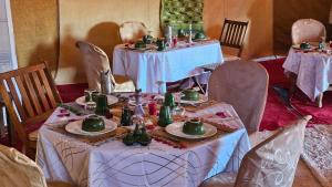 Nejma luxury camp erg chegaga في El Gouera: غرفة طعام مع طاولتين عليها أطباق خضراء