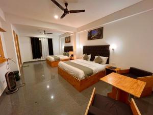 1 dormitorio con 2 camas y ventilador de techo en The Beas Riverside Resort, Manali, en Manali