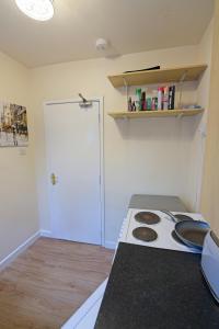 a kitchen with a stove and a white door at Sweet Dream Lodge in Manchester