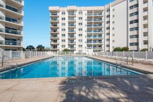 una piscina frente a un gran edificio de apartamentos en Regency Towers 401 East - Sea La Vie 401E, en Pensacola Beach