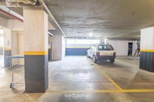 a parking garage with a car parked in it at SPT - Studios Convenientes em Blumenau/SC in Blumenau