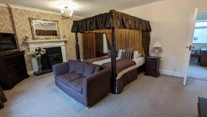 a bedroom with a canopy bed and a couch at East Ayton Lodge Hotel, Scarborough in Scarborough