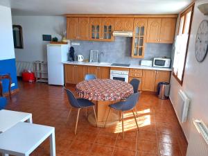 une cuisine avec une table et des chaises dans une pièce dans l'établissement La Tour Fondue Appartement vue mer Grand T2 face a Porquerolles Drap serviette non fournis, à Hyères 16 autres photos