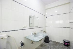ハイデラバードにあるLuxury Room @ Banjarahills Near Care hospitalsの白いバスルーム(シンク、鏡付)