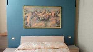 un dipinto su una parete blu sopra un letto di Rosso Marsala a Marsala