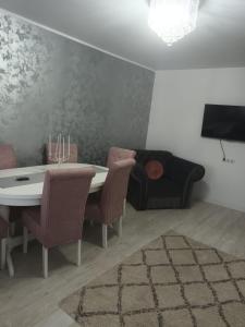SorinaApartament1 في تارجو نيمت: غرفة طعام مع طاولة وكراسي وتلفزيون