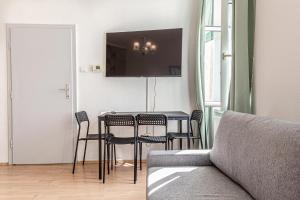 a living room with a table and chairs and a couch at Vienna Getaway -2BR Apartment Central & Comfort in Vienna