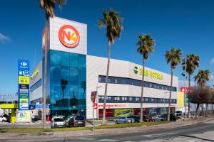 een tankstation met palmbomen voor de deur bij B&B HOTEL Écija in Écija