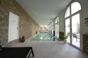 a swimming pool in a room with a brick wall at Manoir de l'évêché in Lisieux
