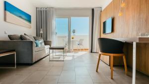 a living room with a couch and a table at Labranda Corralejo Village in Corralejo