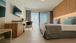 コラレホにあるLabranda Corralejo Villageのベッドとデスクが備わるホテルルームです。
