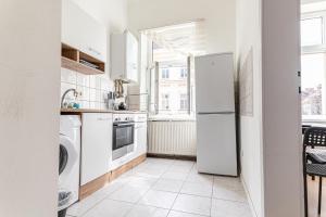 a white kitchen with a refrigerator and a dishwasher at Vienna Getaway -2BR Apartment Central & Comfort in Vienna