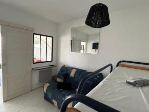Un dormitorio con una cama, un sofá y un espejo. en Terrasse brise marine, en La Grande-Motte 5 fotos más