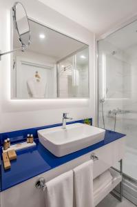 a bathroom with a white sink and a mirror at PANORAMA Orbi Beach Resort Center Suite in Batumi