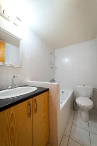 een badkamer met een wastafel, een toilet en een bad bij Hillside Home in Platres in Platres