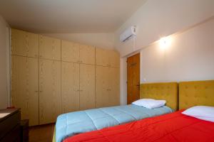 a bedroom with two beds and wooden cabinets at Hillside Home in Platres in Platres