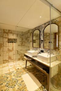 a bathroom with two sinks and two mirrors at Canary Islands Resort & Spa in Lonavala
