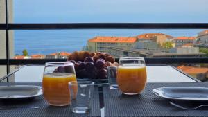 卡尼索的住宿－Azenha Apartment by LovelyStay，一张桌子,上面放着三杯果汁和一盘水果