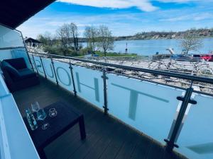 a balcony with a table and a view of a boat at Das Bootshaus in Seeon