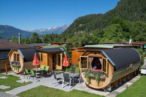 un grupo de cabañas con mesa y sillas en Camping Lazy Rancho - Eiger - Mönch - Jungfrau - Interlaken, en Interlaken
