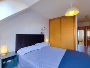 a bedroom with a large bed with a wooden headboard at Vivienda Novo Betanzos in Betanzos