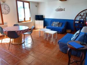 a living room with a blue couch and a table at La Tour Fondue Appartement vue mer Grand T2 face a Porquerolles Drap serviette non fournis in Hyères