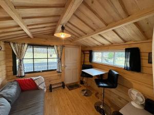 a room with a couch and a desk in a cabin at The Hideout Log Cabin- 2km to Klarälvsbanan and swimming area in Munkfors