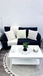 sala de estar con sofá azul y mesa de centro blanca en Modern studio, en Hail