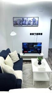 sala de estar con sofá azul y TV en Modern studio, en Hail