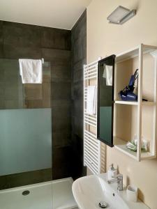 a bathroom with a glass shower and a sink at Le Suite Sul Corso in Cagliari