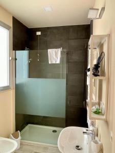 La salle de bains est pourvue d'une douche et d'un lavabo. dans l'établissement Le Suite Sul Corso, à Cagliari