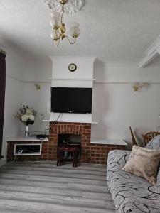 a living room with a fireplace and a television at Luxury Home in Lewisham in Bromley