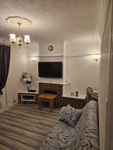 a living room with a couch and a television at Luxury Home in Lewisham in Bromley