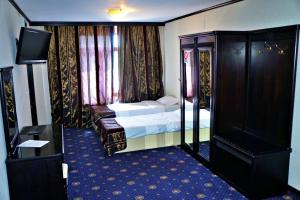 una camera d'albergo con letto e TV di Ambasador a Valea Lupului