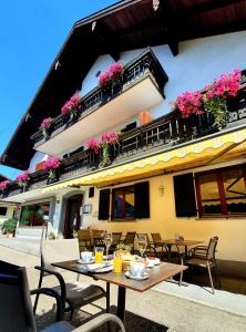 a patio with tables and chairs in front of a building at Hotel Hemetsberger in Attersee am Attersee