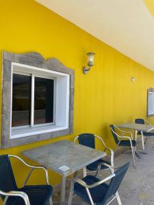 une table et des chaises contre un mur jaune avec une fenêtre dans l'établissement Ocean breeze villamaracuya, à Santa Cruz de Tenerife