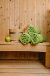 un mucchio di asciugamani verdi e una mela su una panchina di FEWO Immenstadt a Immenstadt im Allgäu
