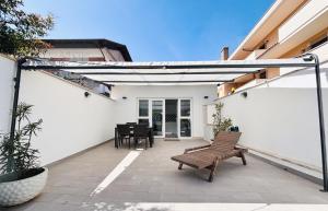 a patio with a bench and a table on it at Maison Blue con Patio in Fregene