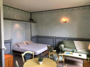 a bedroom with a bed and a couch and tables at Le Domaine du Château des Gipières By Ateya Vacances in Montbrun-les-Bains