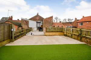 a backyard with a wooden fence and green grass at Henry Court Apartment 3 in York