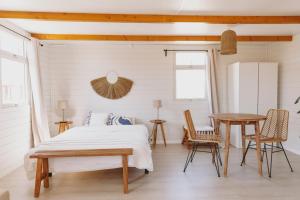 um quarto com uma cama, uma mesa e cadeiras em Dreamsea Bungalows Alentejo em Porto Covo