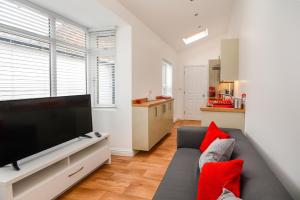 ein Wohnzimmer mit einem Sofa und einem Flachbild-TV in der Unterkunft Henry Court Apartment 3 in York