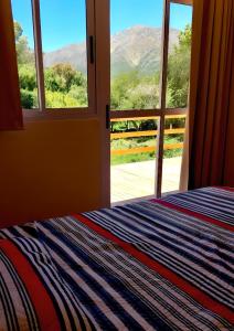 Un dormitorio con una cama y una ventana con vistas. en Casablanca La Granja de Capilla, en Capilla del Monte