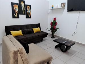 ein Wohnzimmer mit einem schwarzen Sofa und einem Tisch in der Unterkunft Lugar de descanso in Santa Cruz de la Sierra