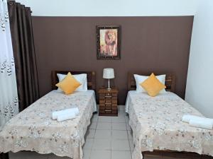 ein Schlafzimmer mit 2 Betten und einem Bild an der Wand in der Unterkunft Lugar de descanso in Santa Cruz de la Sierra