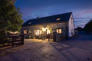 a stone house with lights on the side of it at The Coach House in Bridgend