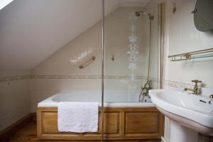 a bathroom with a bath tub and a sink at The Coach House in Bridgend +34 photos