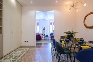 une salle à manger avec une table jaune et des chaises bleues dans l'établissement Residenza Bellavista Design e Vista Mozzafiato, à Bologne
